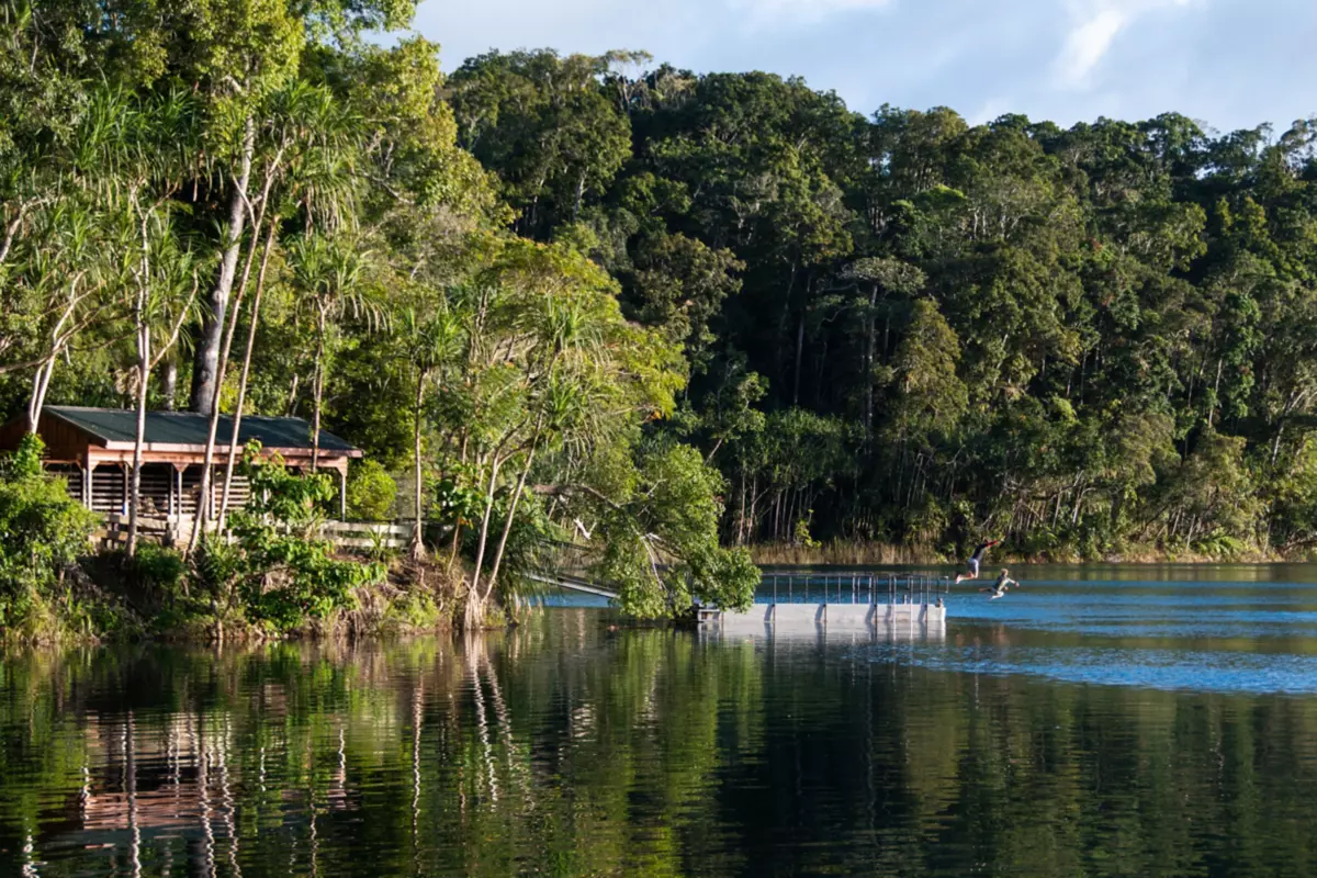 Family jumping into Lake Eacham from the jetty | Free things to do Cairns