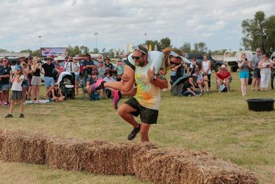 Competitors run through muddy water during a race at Julia Creek Dirt n Dust Festival