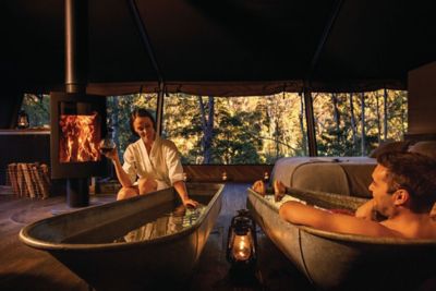 Couple taking baths in their glamping tent