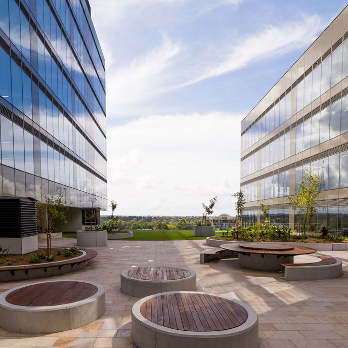 An outdoor terrace at North Shore Health Hub with two buildings on either side