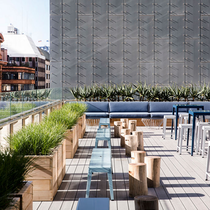 Exterior image of One Farrer rooftop terrace event space with couches and tables, overlooking surrounding buildings