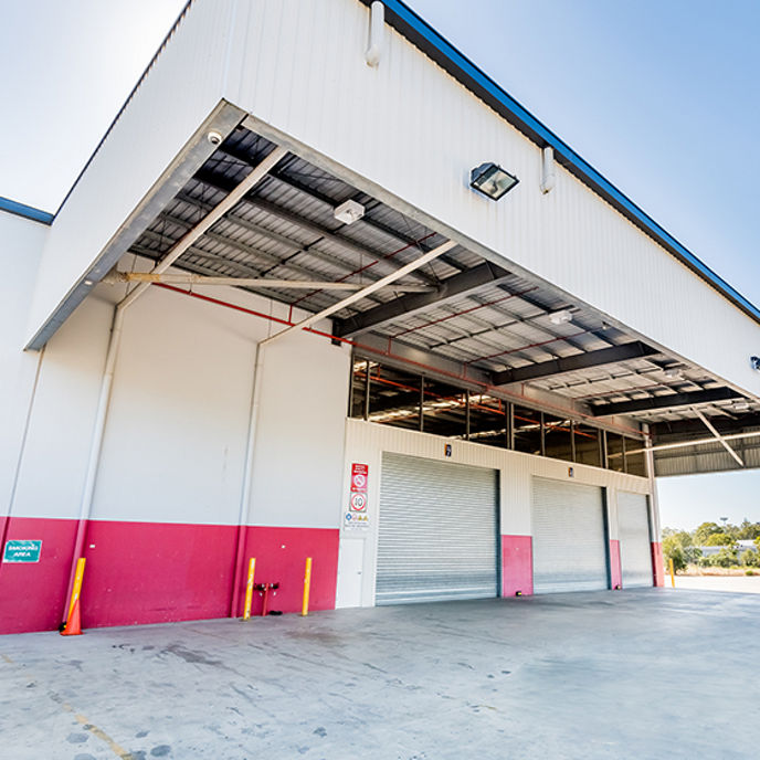 Wide angle exterior image of 42 Manton Street warehouse facilities with loading dock roller doors and awning