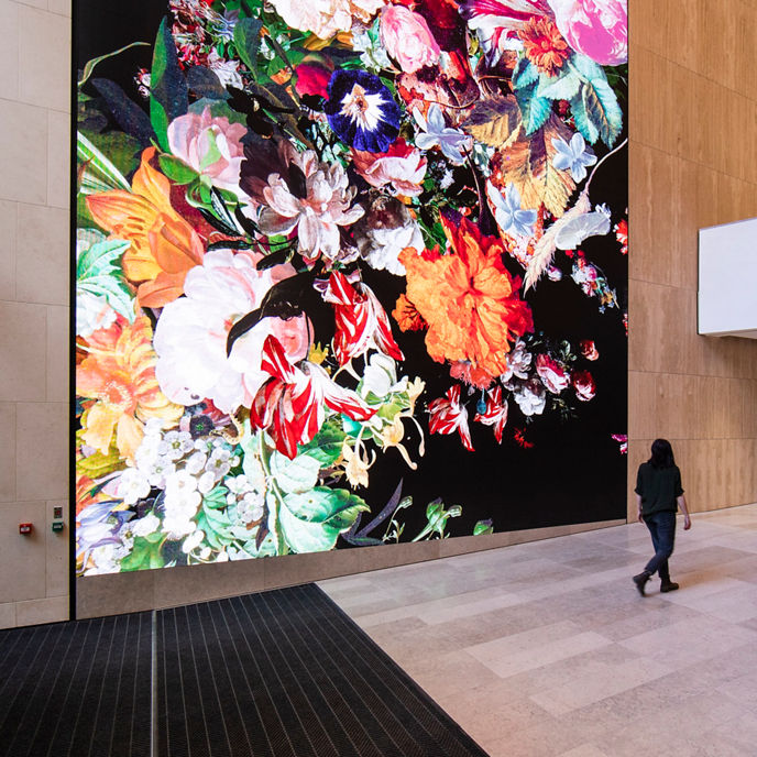 Interior image of 80 Collins South Tower lobby entrance with large digital screen artwork 