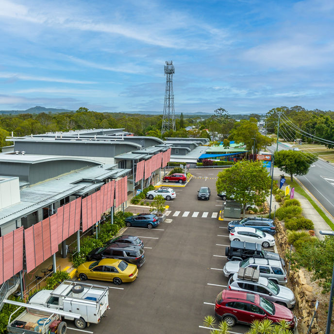 A view of Spring Hill Health and Innovation Centre from the street with a red-roofed house in front 