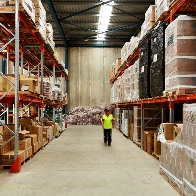 Inside of a warehouse with a person walking between rows of shelves