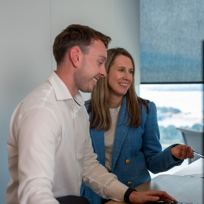Dexus employees in a conference hall with two people presenting on stage 