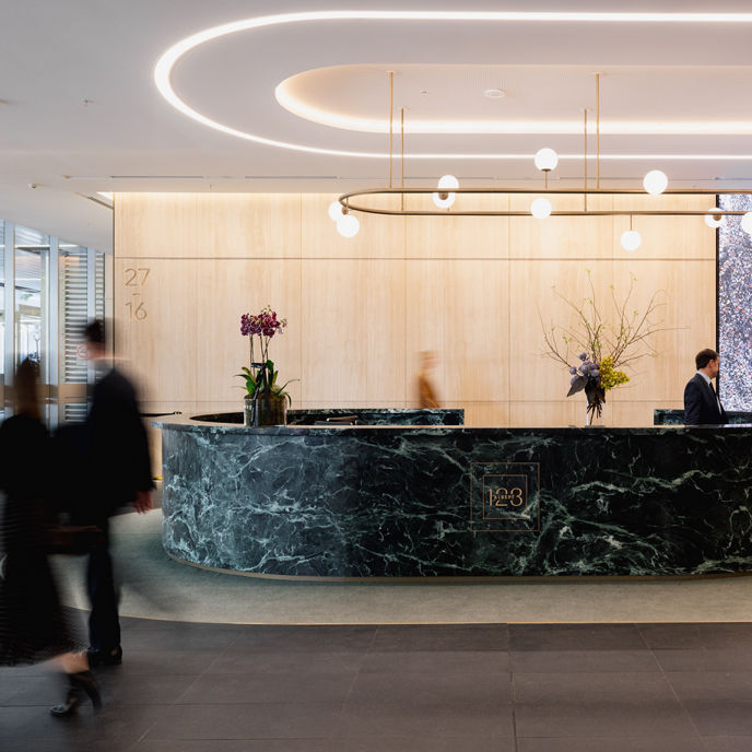 A concierge and customer at a marble front desk at 123 Albert Street