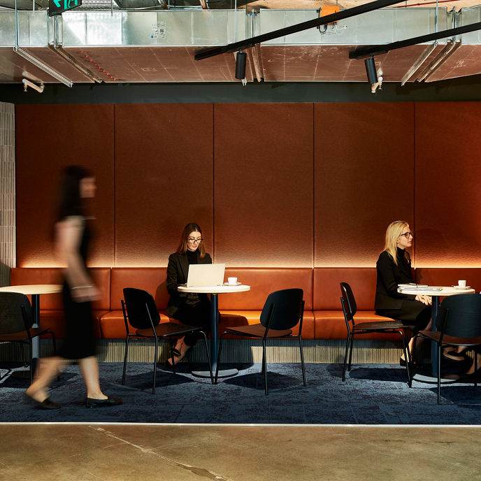 Interior image of flexible office working space with woman seated and working from laptop