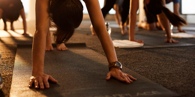 People in a yoga class doing a downward dog pose 