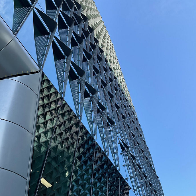 The exterior of the Australian Bragg Centre, focusing on its design with a blue sky in the background 