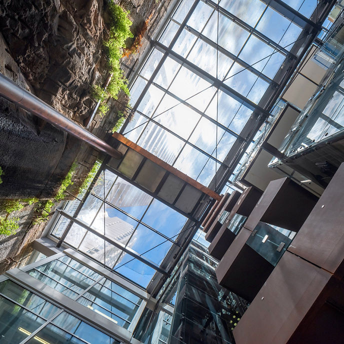 Image looking up through glass ceiling to the sky  