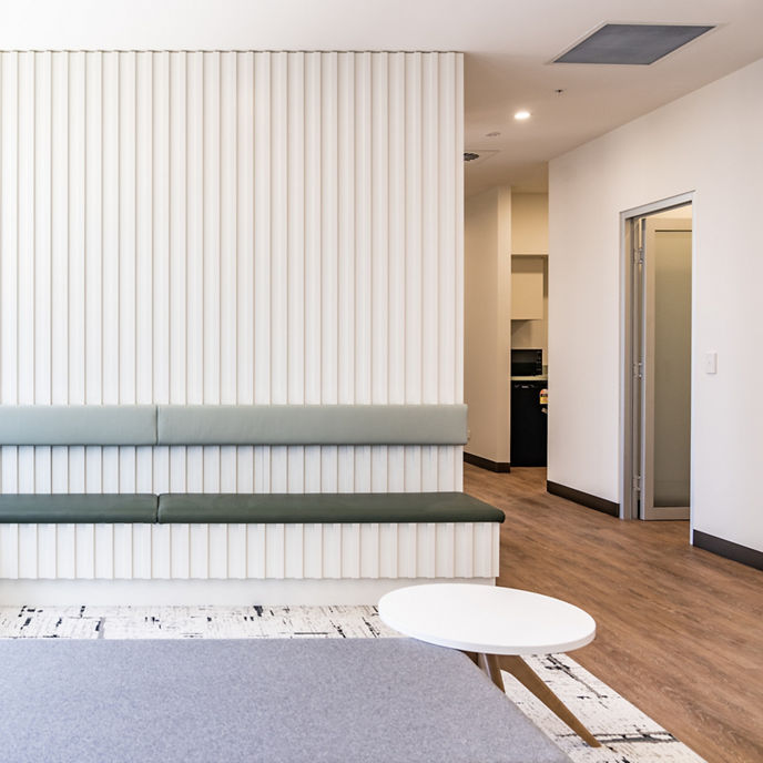 North Shore Health Hub suite with a white wall and grey bench