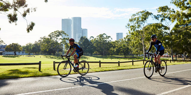Two people cycling in a park 
