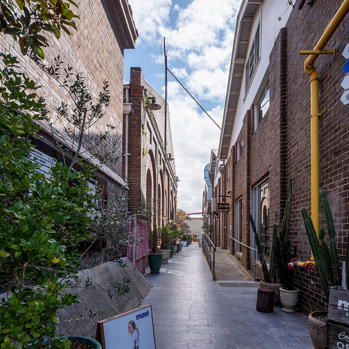 Exterior image of The Mill Alexandria industrial style open air precinct corridor with retail stores lululemon, Mavi Store and Grace Loves Lace