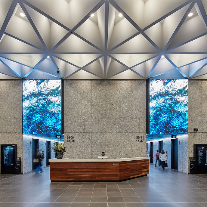 Interior image of 385 Bourke Street Tower lift lobby with concierge and digital artwork 