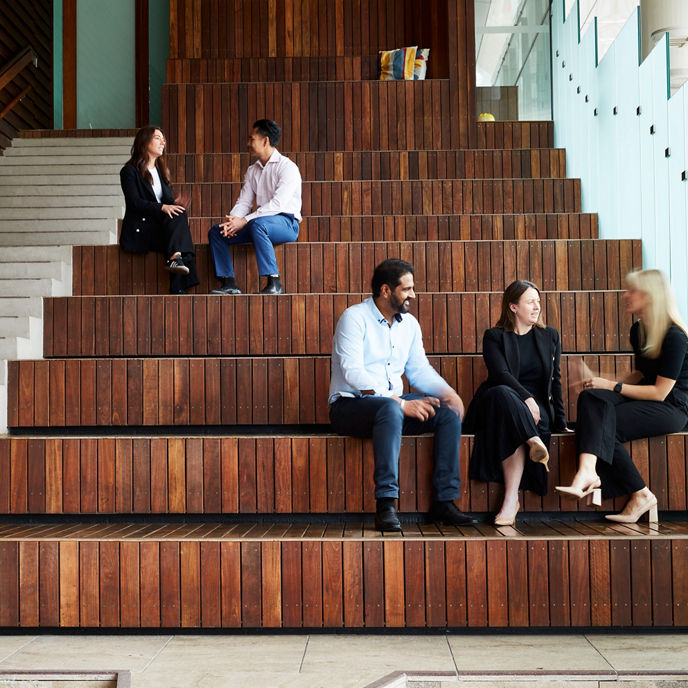 People in corporate clothes engaged in conversation on stairs at 480 Queen Street in Brisbane