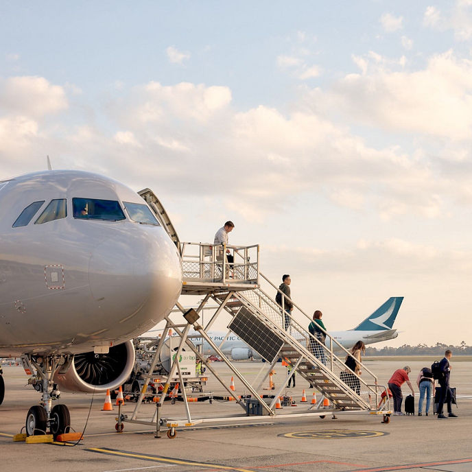 Image of people walking down the stairs and deboarding a plane at Melbourne Airport