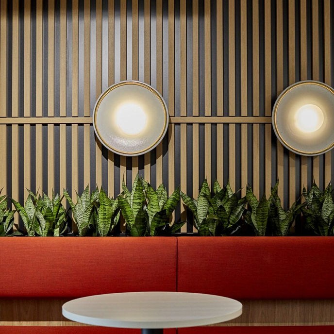 Interior detail image of breakout area chair and table with greenery and lighting