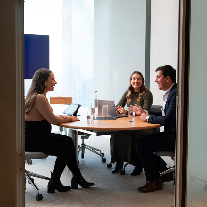 Three people in a meeting room