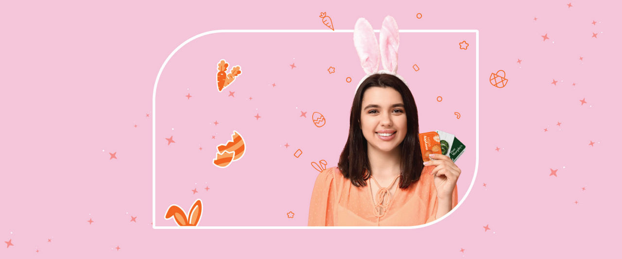 A woman wearing bunny ears and holding gift cards against a pink background with Easter themed illustrations.