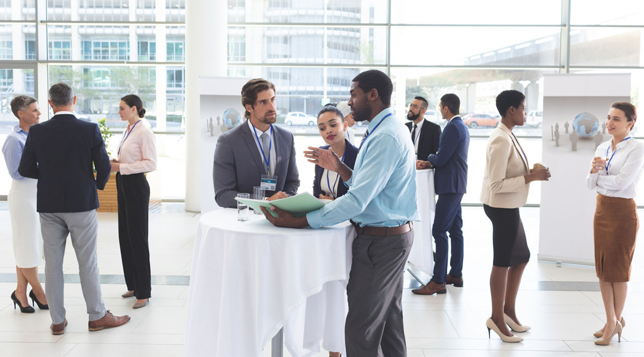 Business people discussing over documents at table during a seminar