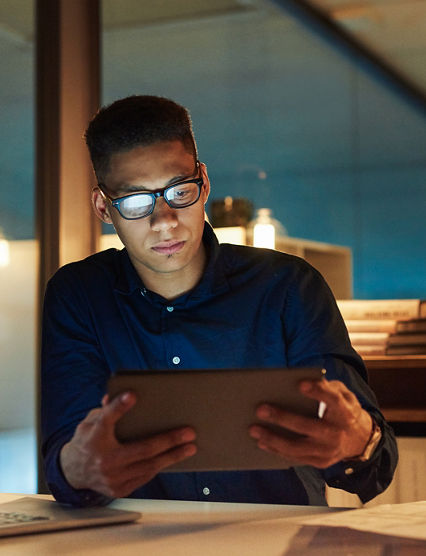 Shot of a young businessman using a digital tablet during a late night at work
