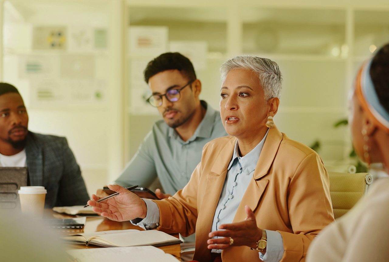 Senior, woman or business people in meeting with talking in teamwork for creative decision making. Collaboration, manager or professional employees with paperwork for project brainstorming in office.