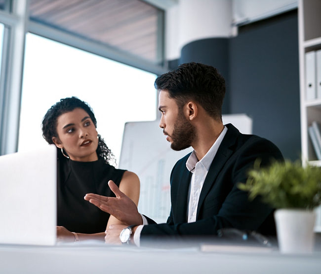 Serious, business meeting and people with laptop for performance review, communication and feedback. Corporate team, man and woman with computer in office for discussion and collaboration on project.