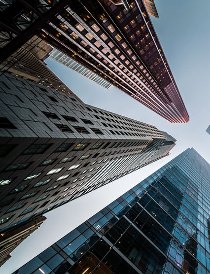 Business and finance concept, looking up at high rise office building architecture in the financial district of a modern metropolis.