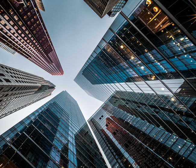 Business and finance concept, looking up at high rise office building architecture in the financial district of a modern metropolis.