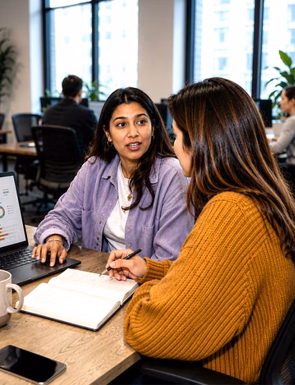 Coworkers collaborating with analytics dashboard laptop