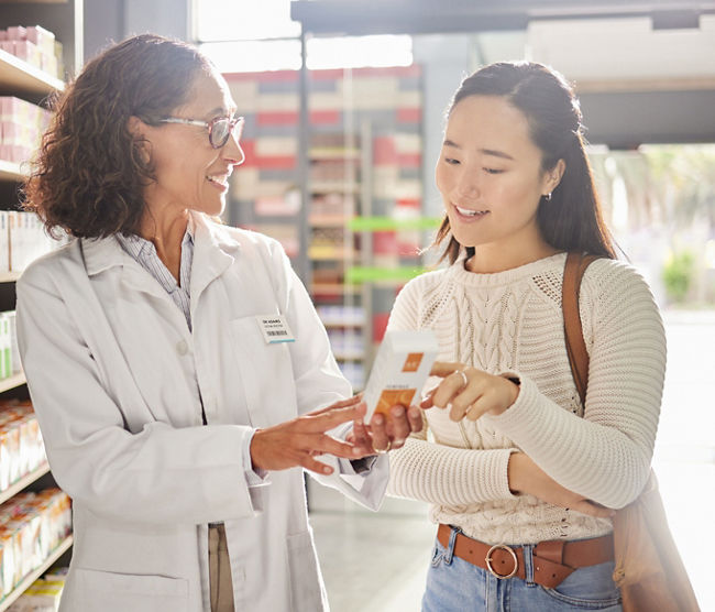 Asian woman, medicine shopping or pharmacist in pharmacy for retail healthcare product information. Women or friendly doctor helping a customer with store medication advice, pills or medical drugs.