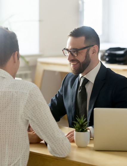 Friendly lawyer or financial advisor in suit consulting young couple, smiling investment broker or bank worker making loan offer, giving legal advice, selling insurance or real estate to customers