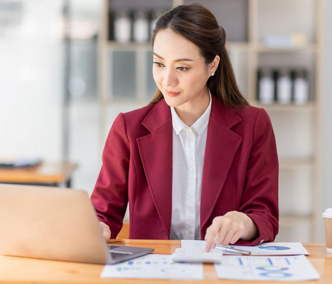 Asian woman working laptop in workplace, Business woman wearing red jacket suit busy working on laptop computer checking finances, investment, economy, saving money or insurance concept