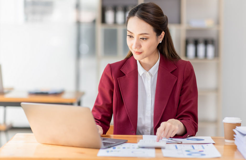 Asian woman working laptop in workplace, Business woman wearing red jacket suit busy working on laptop computer checking finances, investment, economy, saving money or insurance concept