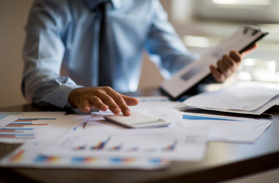 Business accounting concept, Business man using calculator with computer laptop, budget and loan paper in office.