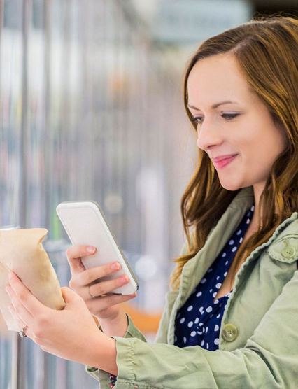 Shopper scanning a grocery item with her phone