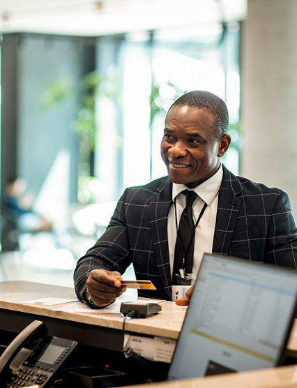 Businessman paying stay at hotel with credit card at reception