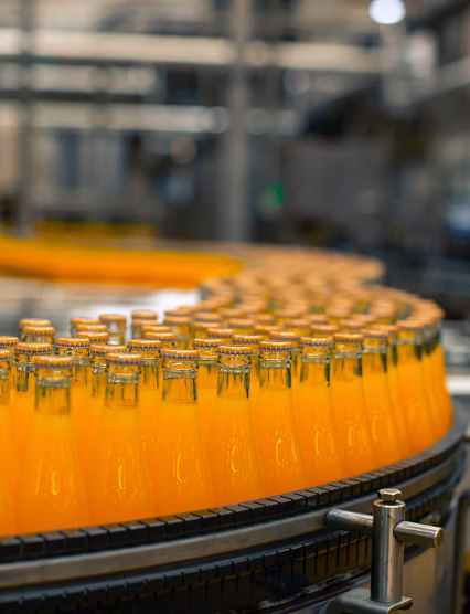 Beverage factory interior. Conveyor flowing with bottles for juice or water.