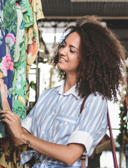 Young woman shopping clothes in a market stall