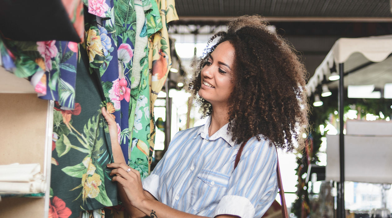 Young woman shopping clothes in a market stall