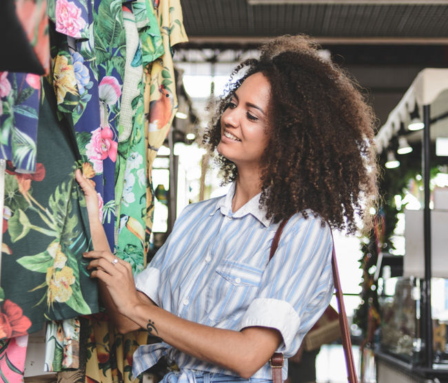 Young woman shopping clothes in a market stall