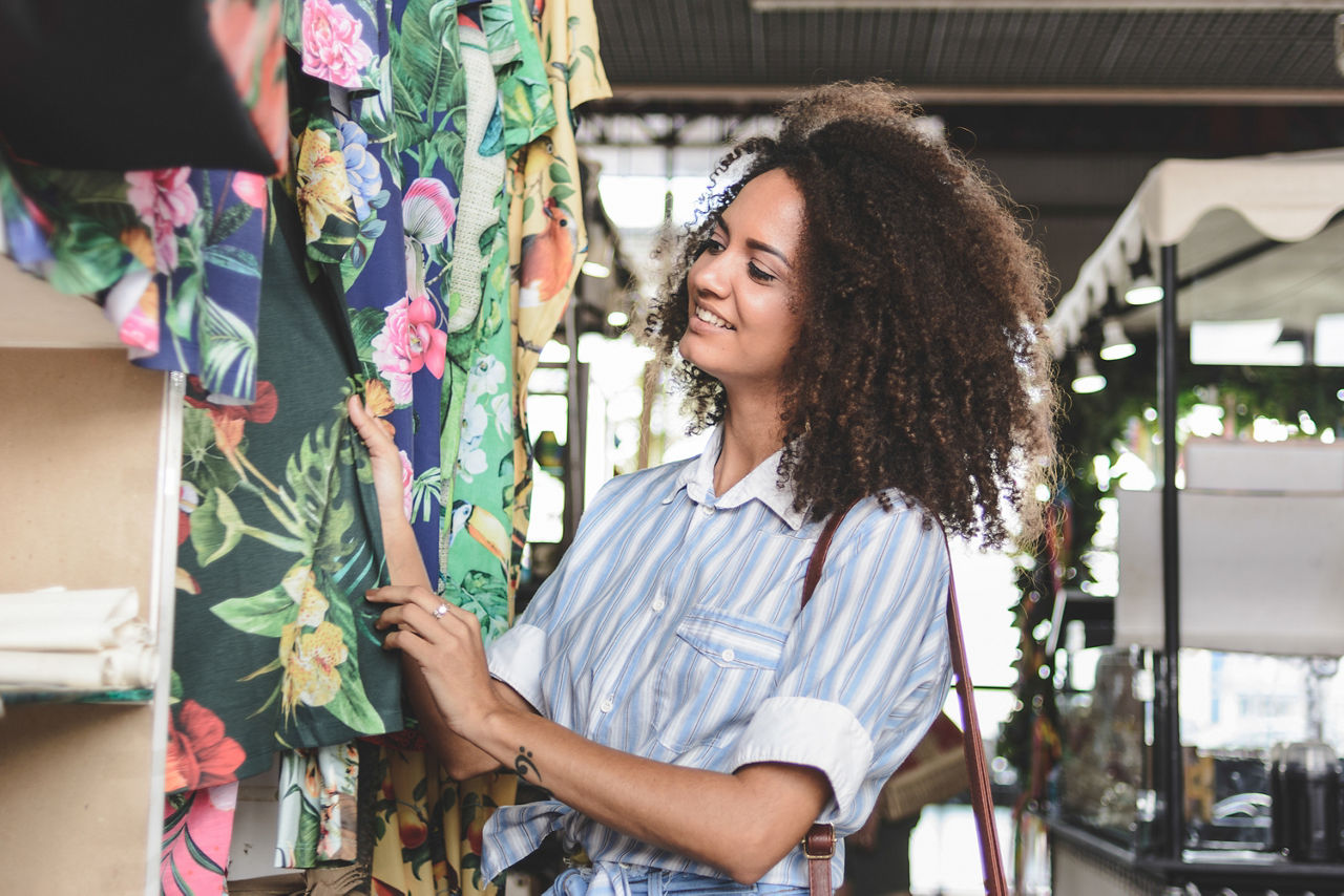 Young woman shopping clothes in a market stall