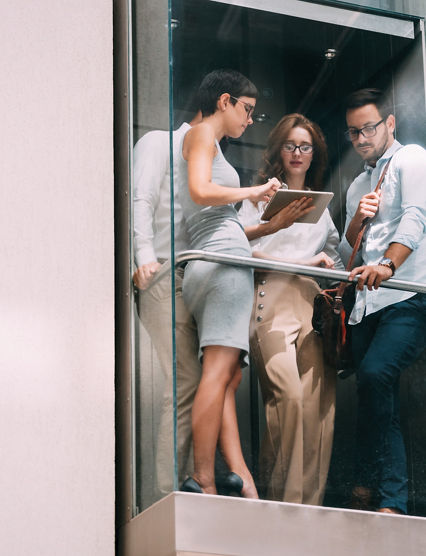 Picture of young attractive businesspeople talking in elevator