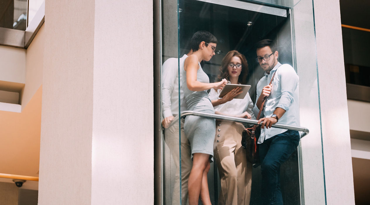 Picture of young attractive businesspeople talking in elevator
