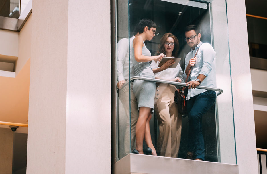 Picture of young attractive businesspeople talking in elevator