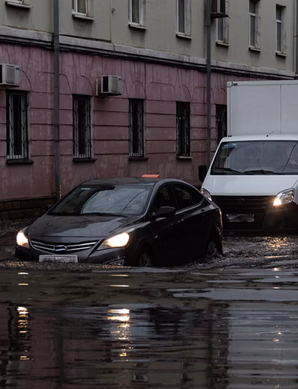 Cars drive through the flooded city