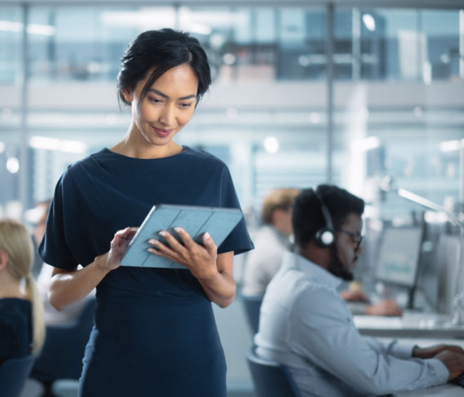 Successful Businesswoman in Stylish Dress Using Tablet Computer, Standing in Modern Diverse Office Working on Financial, Business and Marketing Projects. Portrait of Beautiful Asian Manager.