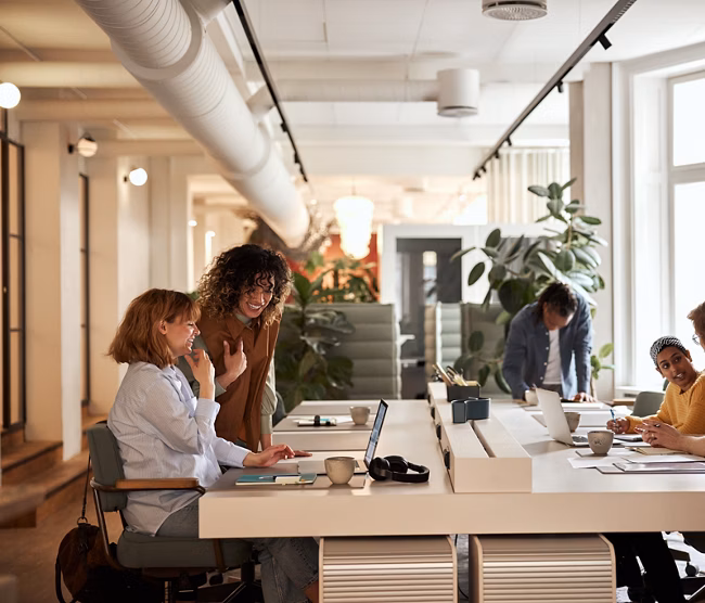 Diverse group of focused young businesspeople working together around a table in a modern office