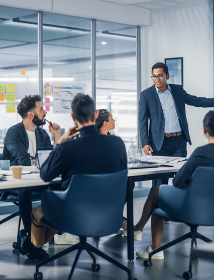 Presentation in Multi-Ethnic Office Conference Room. Meeting of Diverse Young Entrepreneurs, Specialists, Talking, Using TV for infographics. Businesspeople Develop e-Commerce Startup.